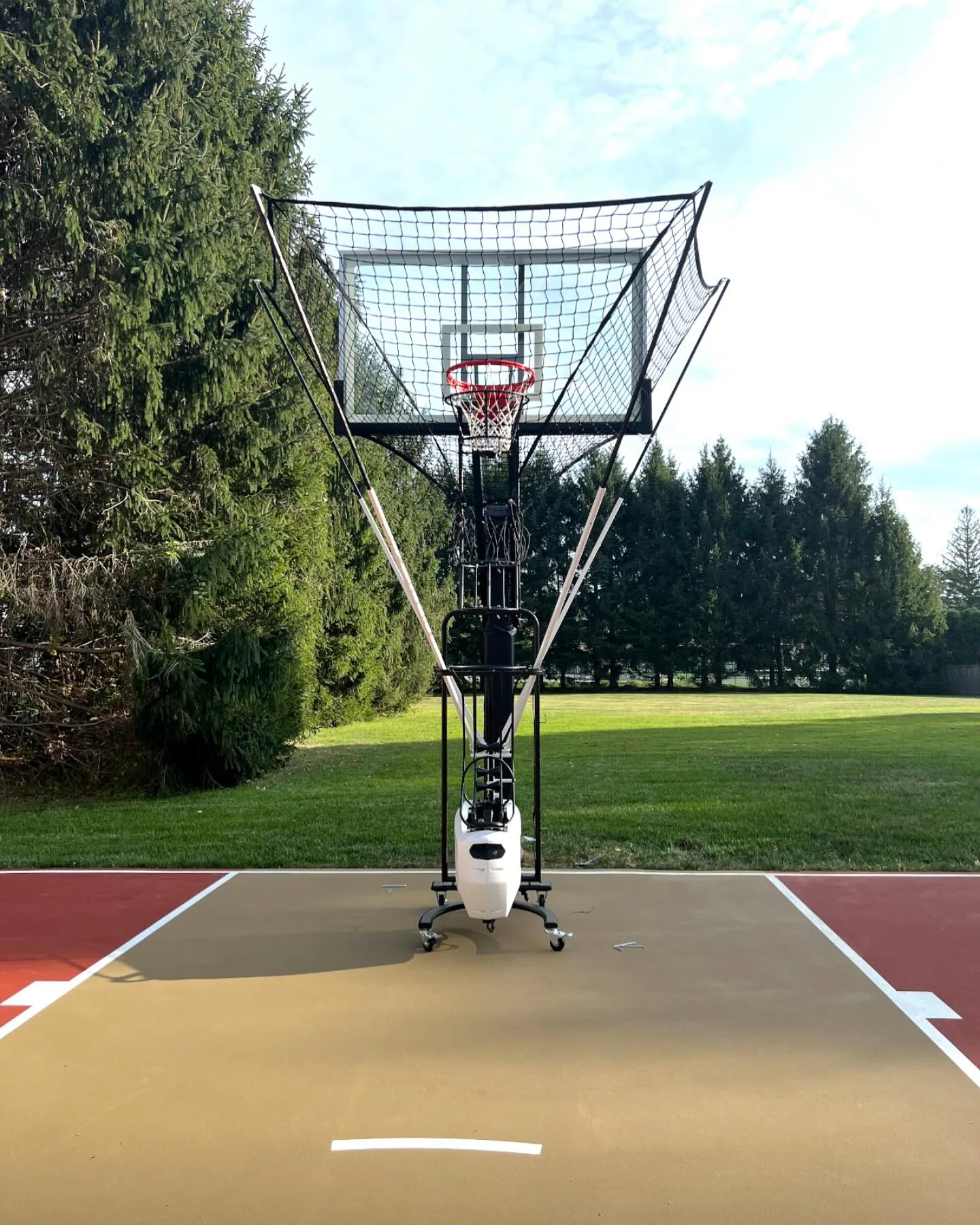 Professional basketball hoop setup on an outdoor court with ball return system