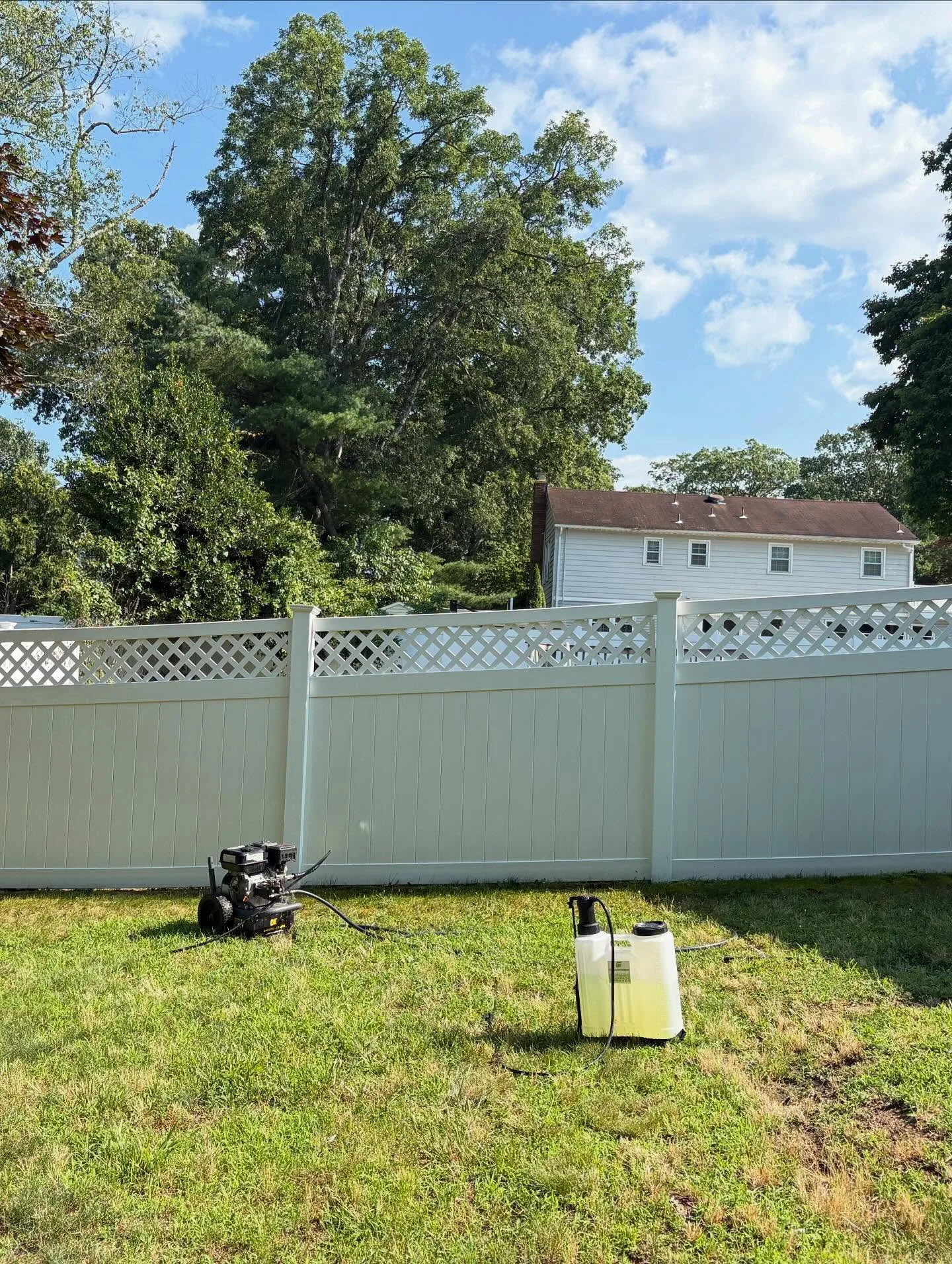 Clean white vinyl fence after professional pressure washing, bright and restored